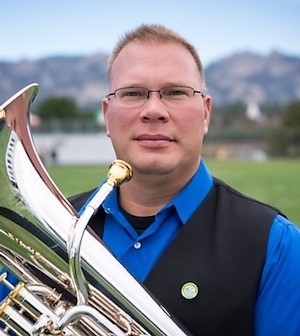 Dr. Nathan Gay outside holding a low brass instrument