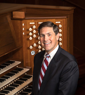 Dr. Jack Mitchener at a pipe organ with three manuals