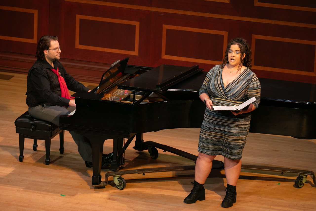 A piano player at a grand piano and a female singer