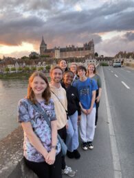students standing on a bridge in front of a castle in France