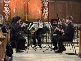 Five students in wind quintet perform in a church in London
