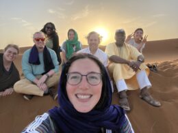 Student selfie in Morocco with sun setting behind them