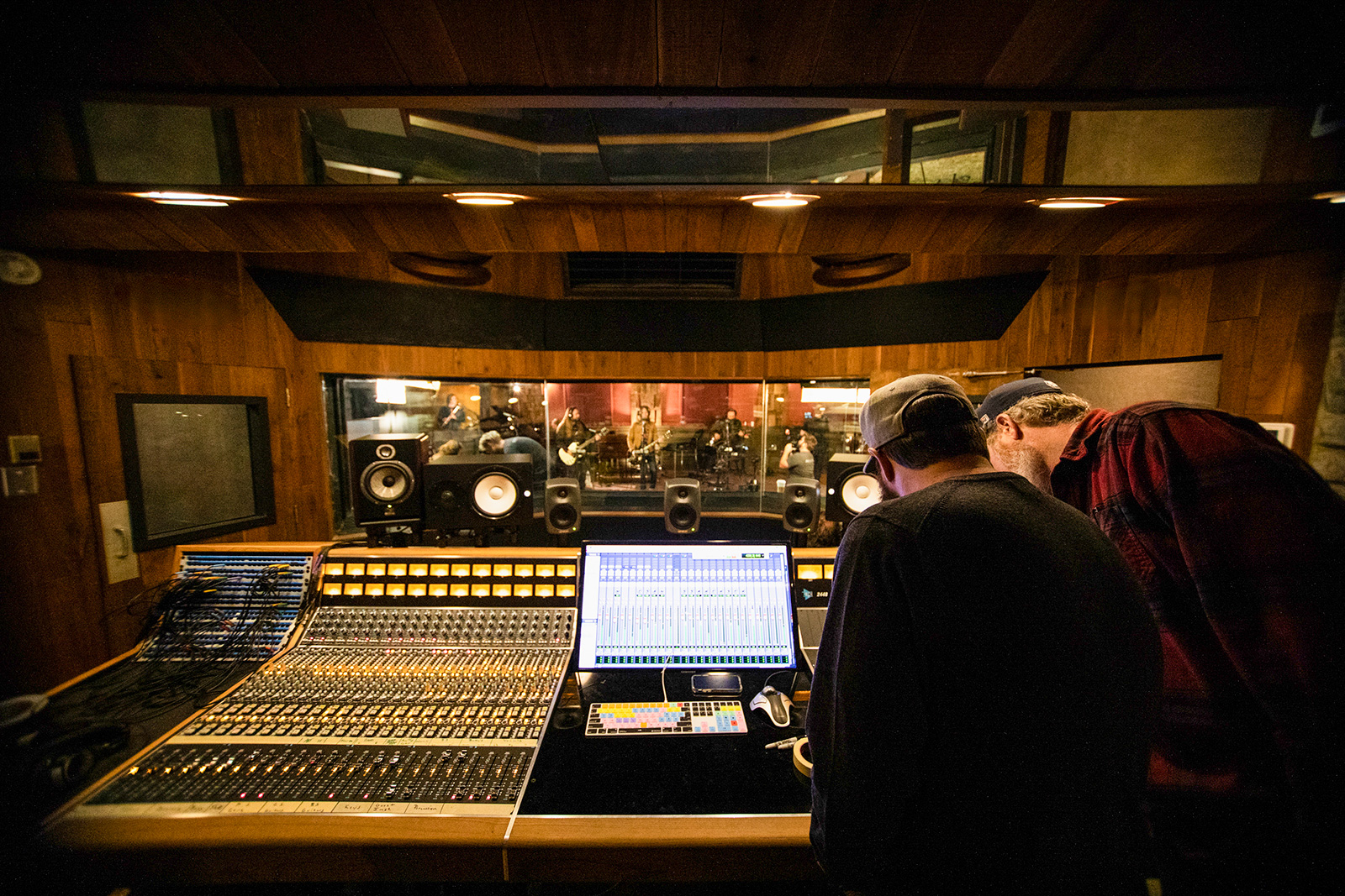Two individuals looking over a sound board in studio