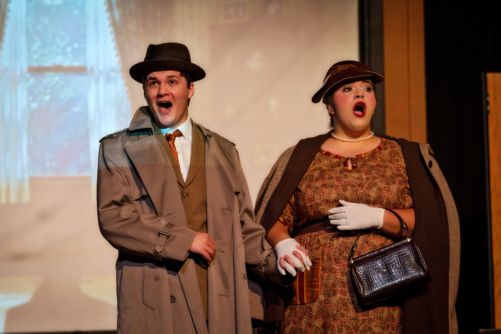 Opera photo of a 40s couple on stage, singing and holding hands