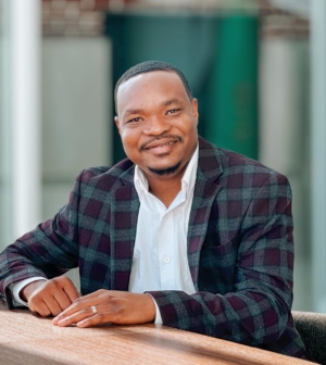 Eric Amouzou, seated and smiling