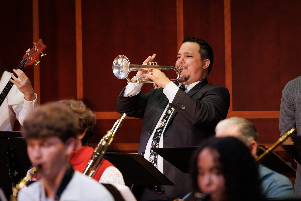 a trumpet player solos on stage with the jazz ensemble
