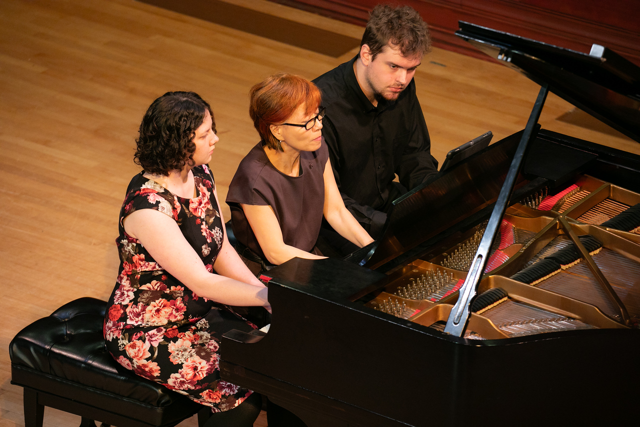 Three pianists play at one piano