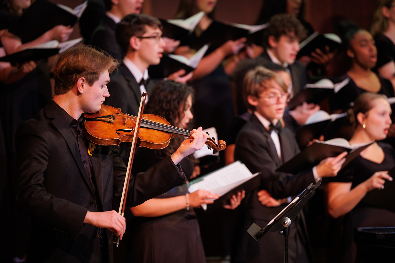 A violinist on stage with Mercer Singers